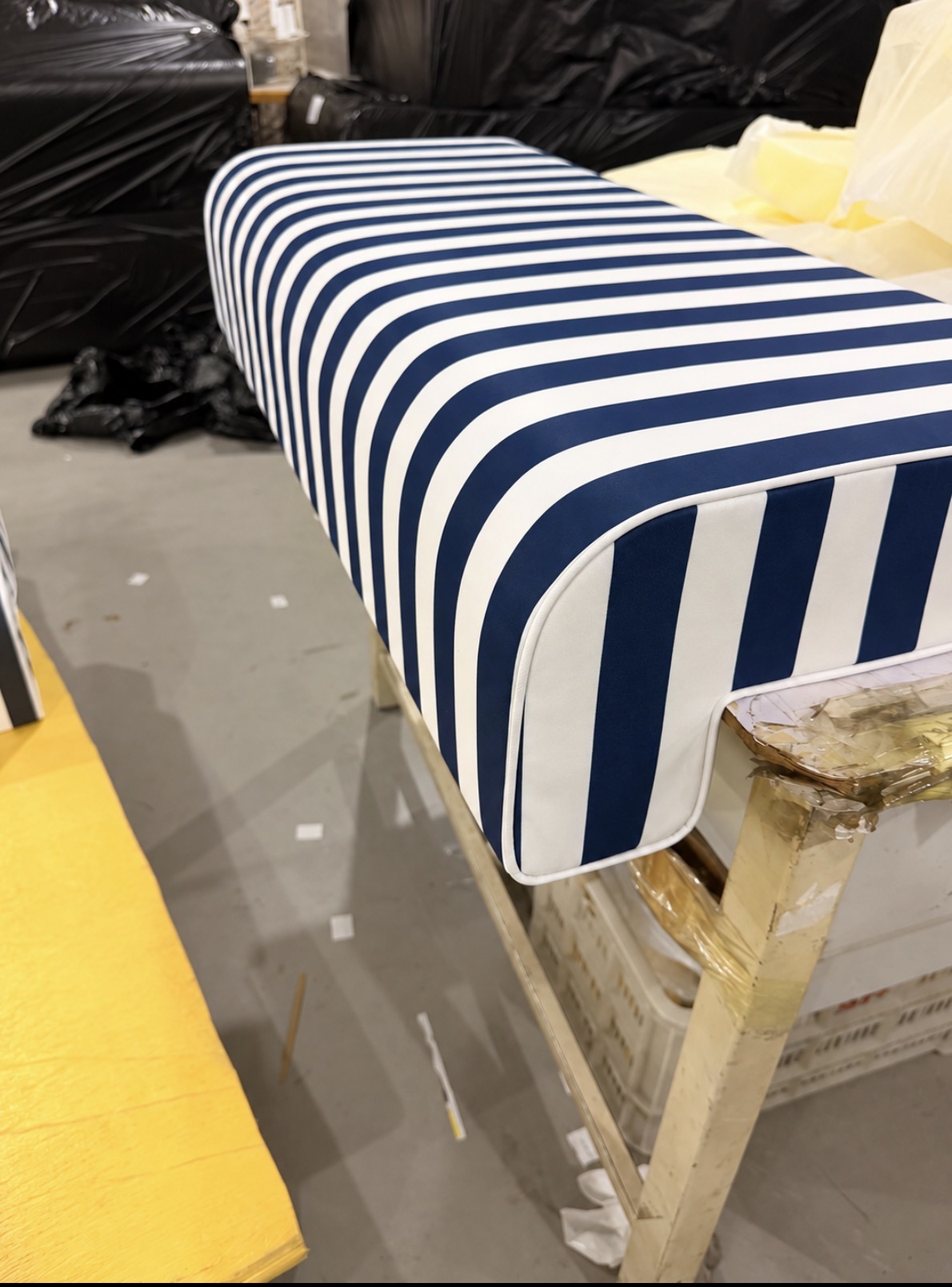 Aegean Navy and white striped Akti cushion in the workroom with its piping detail