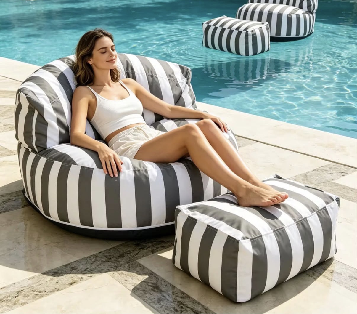 Naxos Stone grey-and-white striped Kefi lounge chair with matching pouf beside a pool