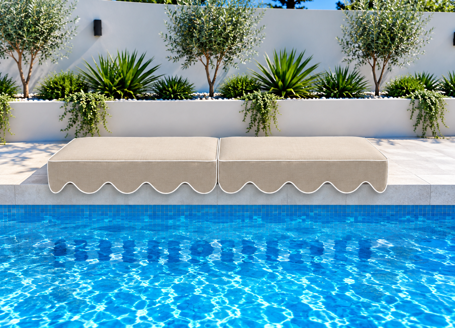 Two Riviera Santorini Sand Akti Limited Edition cushions showing their scalloped lips beside the pool
