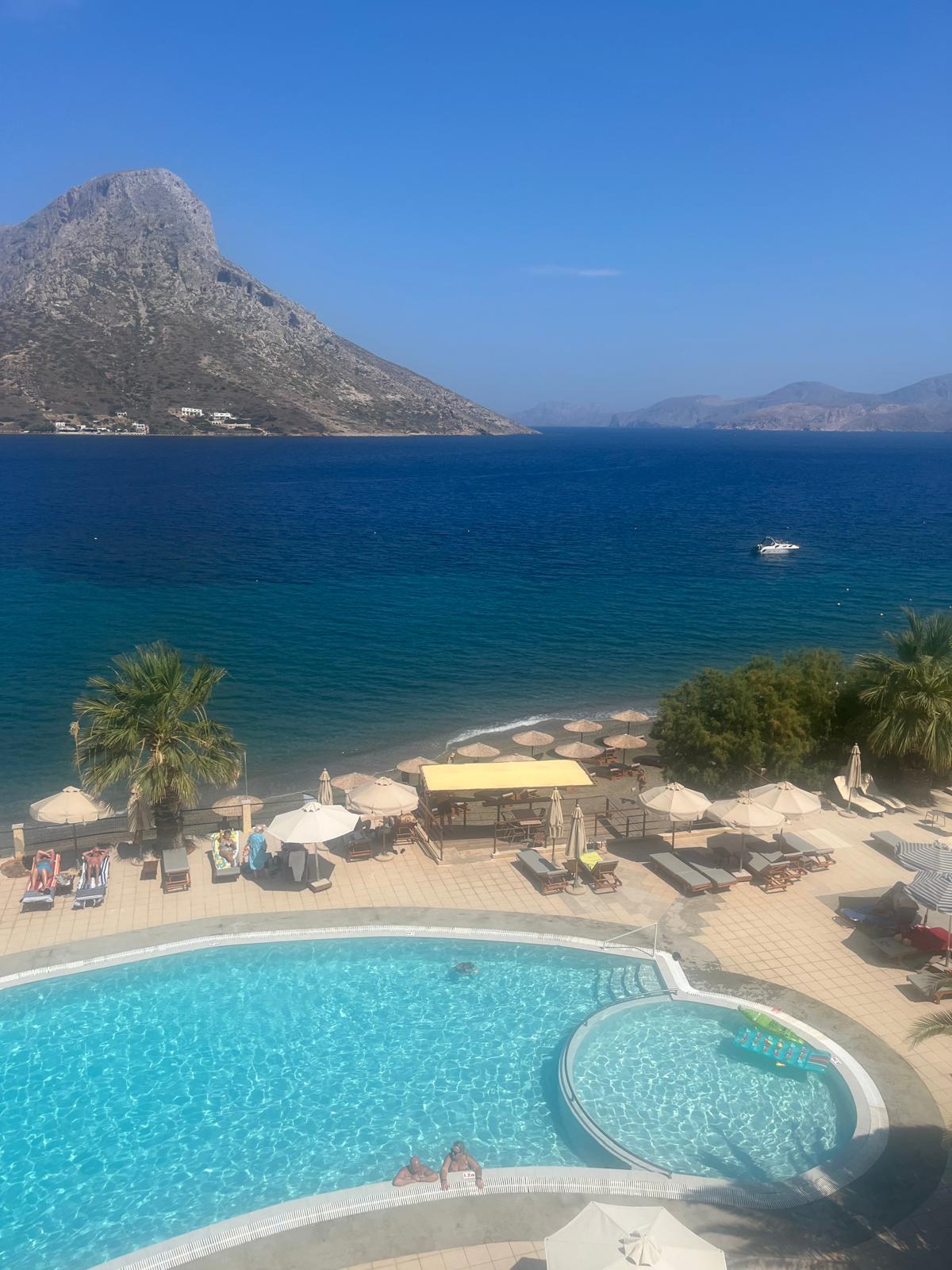 A turquoise seaside pool in Greece looking out over the bay to a rocky island
